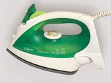a green and white steam iron sitting on a white surface