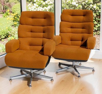 une paire de fauteuils orange devant une grande fenêtre dans un salon