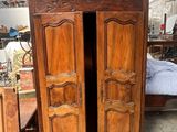 a wooden armoire with two doors open in a room
