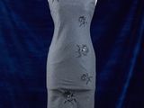 une robe posée sur un mannequin, devant un fond bleu