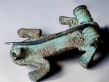 a small metal object with a lizard on it ' s back