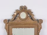 a mirror with a gold frame and a clock on it