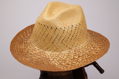 un chapeau de paille posé sur un porte-chapeaux