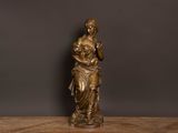 an antique bronze statue of a woman holding a baby on a wooden table