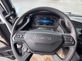 a steering wheel and dashboard of a vehicle in a parking lot