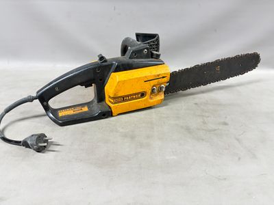 une tronçonneuse jaune et noire posée sur une surface blanche