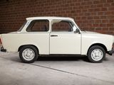 a small white car parked in front of a brick wall