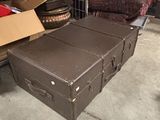 une valise marron posée par terre à côté d'une pile de cartons