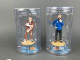 pair of figurines of a man and a woman in a glass case