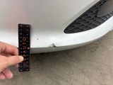 a person holding a ruler in front of a car