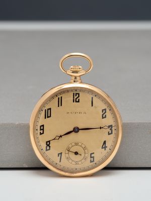 an old pocket watch sitting on top of a table next to a box