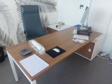 a desk with a chair and a laptop on it