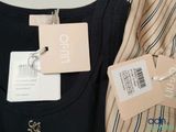 two shirts with tags on them are hanging on a hanger
