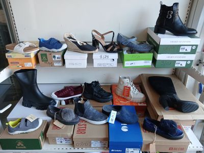 de nombreuses paires de chaussures sur une étagère dans une pièce