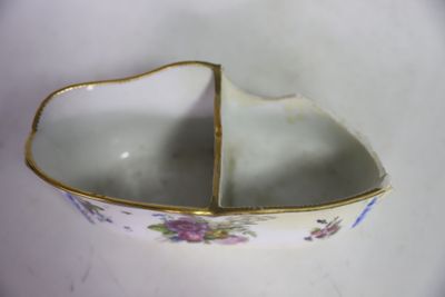 un petit bol blanc bordé d'or posé sur une table
