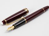 two fountain pens sitting next to each other on a white surface