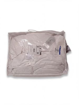 un sac de vêtements blancs posé sur une table blanche