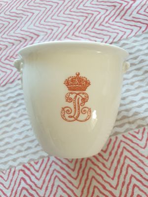 une tasse blanche ornée d'une couronne dorée