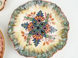 a plate with a flower design on it next to other plates