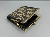 portefeuille en cuir noir et doré, orné d'un motif noir et doré