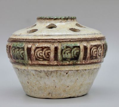 un gros plan d'un pot en céramique orné de motifs