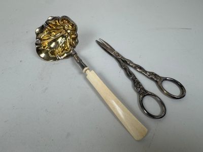 une paire de ciseaux et une cuillère posés sur une table