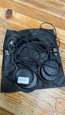 un gros plan sur un casque posé sur un sac, sur un plancher en bois