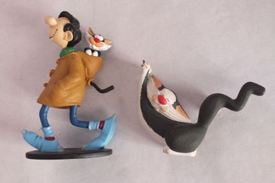 deux figurines représentant un homme et un chien sur un skateboard