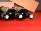 several bottles of wine are lined up on a red table