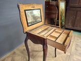 a small wooden table with a mirror on top of it