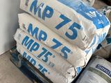 several bags of cement stacked on top of a pallet next to a wall