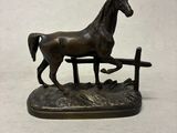 statue d'un cheval dans un espace clôturé, sur fond blanc
