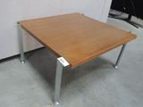 a wooden table with metal legs in a room