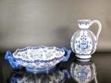 un vase bleu et blanc et un bol posés sur une table
