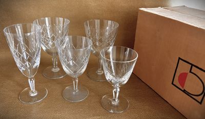 four empty wine glasses sitting on a table next to a box