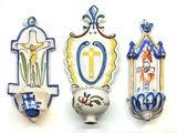 trois plaques murales en céramique ornées de symboles religieux sur un fond blanc
