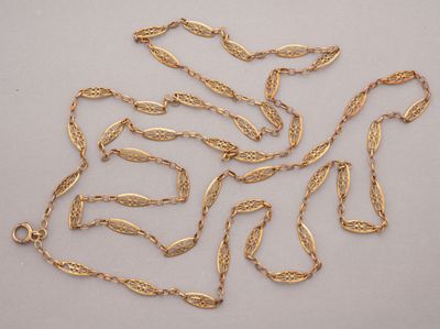 a close up of a bunch of gold chains on a white surface