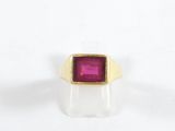 Gros plan sur une bague en or ornée d'une pierre rose