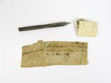 an old piece of paper with writing and a pen sitting on top of it