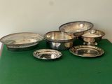 silver plated bowls and pans on a green table