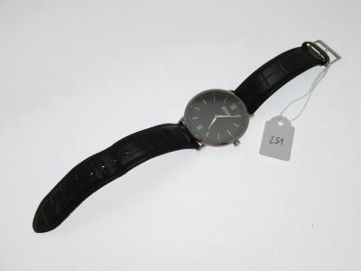 une montre posée sur une table, avec une étiquette de prix accrochée dessus