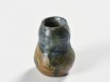 a small vase that is sitting on a white surface