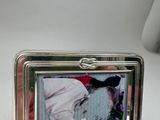 a silver picture frame with a picture of a man kissing a woman