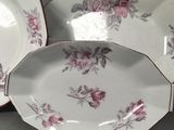 two white and pink plates with floral designs on them on a table