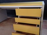 an image of a yellow desk with four drawers