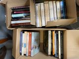 deux cartons remplis de livres posés par terre