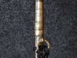 a close up of a black and gold cane with a knot on it