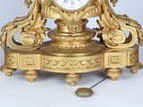 a gold clock that is sitting on top of a table