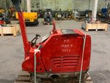 une machine rouge posée sur une palette dans un entrepôt