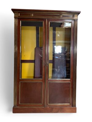 une armoire en bois avec une porte vitrée et une valise
